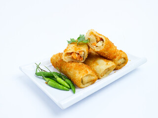 Indonesian risoles filled with vegetables, served with fresh green chilies on a white plate. Crispy breadcrumb coating on white background