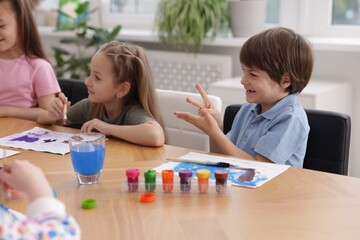 Fototapeta premium Kids painting at table indoors. Learning to draw