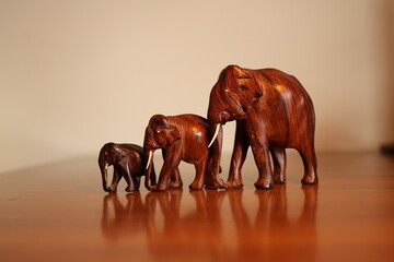handcrafted wooden elephant family on light background © Nadiia