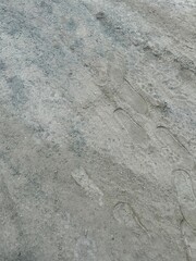 Footprints on a dry dusty dirt road. The shoe prints and soil texture create a dynamic pattern. Useful for themes of walking, travel, path, and direction.