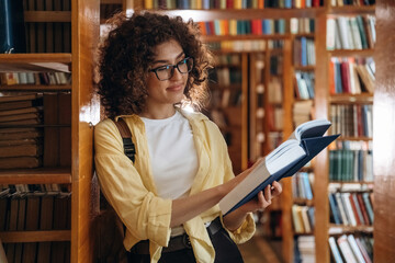 Reading the book. Beautiful woman is in the library
