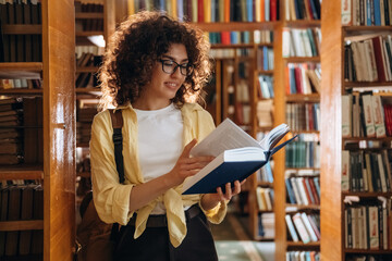 Reading the book. Beautiful woman is in the library