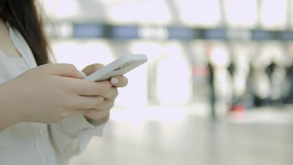 Woman is holding a cell phone in her hand. She is looking at the screen and she is focused on something. Concept of modern technology and the importance of staying connected in today world