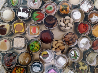 Different Sweets in Small Bowls Place in a Plate Together called Chappan Bhog in an Indian Hindu...