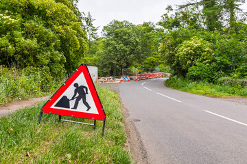Country Road Stone Bridge Under Repair with Warning Sign Lined with Trees