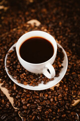 Close-up of roasted brown coffee beans falling against white background, showcasing texture, aroma, freshness, and energy for a morning brew.