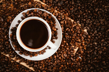 Close-up of roasted brown coffee beans falling against white background, showcasing texture, aroma, freshness, and energy for a morning brew.