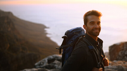 Happy man, portrait or hiking on mountain sunset with backpack for outdoor adventure or journey....