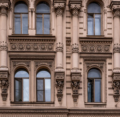 The facade of an ancient building with columns and stucco.