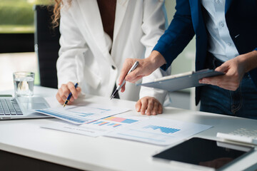 Diverse professionals collaborate on project analysis with financial graphs. Strategic teamwork and insights drive company growth and success..