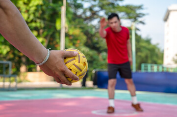 Sepaktakraw player holding ball ready to serve in sepak takraw outdoor court