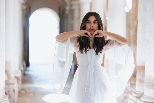 Bride in elegant wedding dress forming heart shape