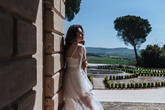 Bride in elegant gown enjoying sunny landscape view