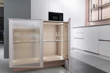 kitchen cabinet with glass doors and light inside. Beautiful wine glasses on shelves. close-up....