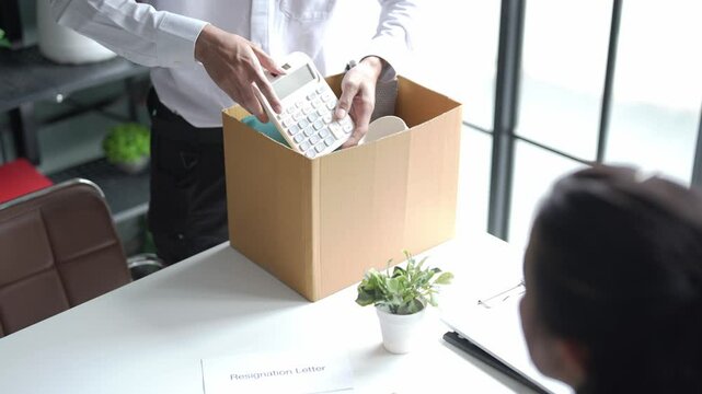 Employees put things in boxes in the office. After resigning from work
