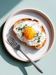 Egg on toast served on a plate with fork resting beside it for a simple breakfast meal