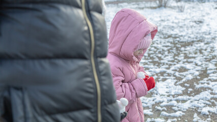 Grandfather walks with his granddaughters after school in the park in sunny winter day