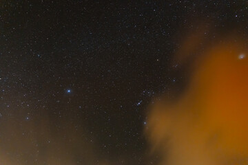 Starry night sky with drifting clouds and cosmic atmosphere

