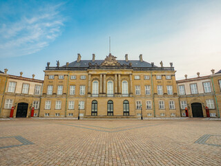 Obraz premium Levetzau's Palace (Christian VIII's Palace) in Amalienborg, Copenhagen—classic neoclassical architecture with a grand courtyard under a bright blue summer sky.