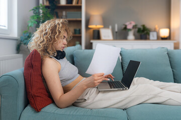 Young woman freelance worker small startup company business owner calculating tax return with data on laptop computer. Working at home office, professional occupation female modern technology user