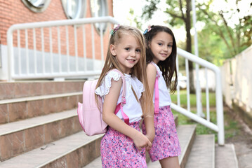 Fototapeta premium Two little sisters at school. Back to education