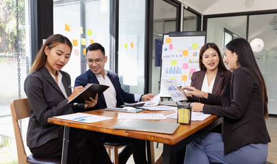 Fototapeta premium Group of Asian business working plan analysis project brainstorm in modern office, Asian businesspeople team working together, Business startup and company strategy planning concept. 