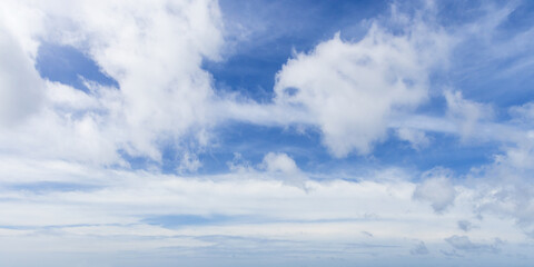 Different types of white clouds scatter across a blue sky, photo panorama
