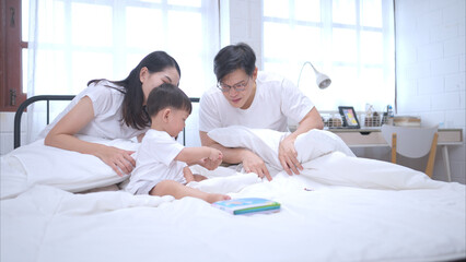 Obraz premium Before putting the kids to bed, parents, and kid unwind and play in the bedroom