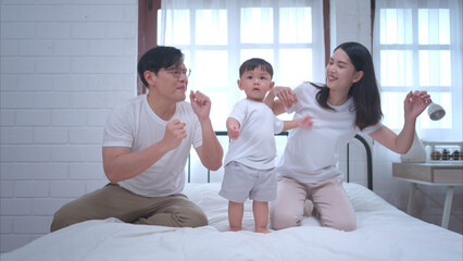 Fototapeta premium Before putting the kids to bed, parents, and kid unwind and play in the bedroom