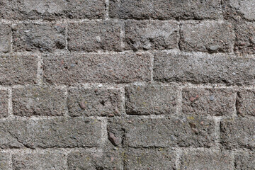 Detailed view of a weathered brick wall showcasing its rugged texture