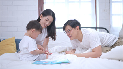 Obraz premium Before putting the kids to bed, parents, and kid unwind and play in the bedroom