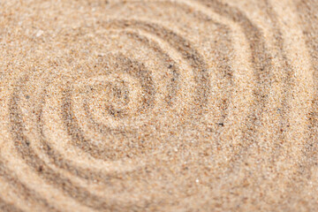 Close-up view of fine sand forming spiral shapes, abstract photo