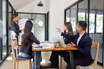 Fototapeta premium Group of Asian business working with analysis project brainstorm in modern office, Asian businesspeople team working together, Business startup and company strategy planning concept.