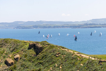 Landscape from the Santander Lighthouse. Steep rocks falling into the sea and sailboats in the...