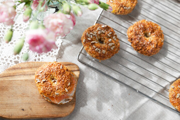 Healthy homemade oat bagels with salmon on rustic sunny background. Place for text.