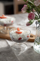 Healthy homemade chia dessert with strawberry and coconut on sunny cozy background 