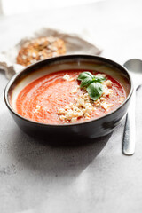 Gazpacho, cold tomato soup on grey table. Minimalistic, place for text