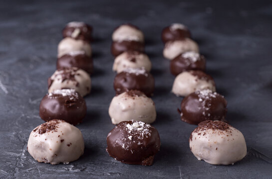 Rows of chocolate truffles on a dark background