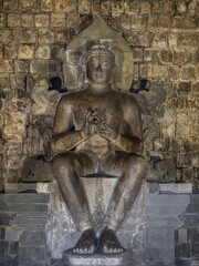 Obraz premium Vertical view of ancient Vairocana (or Maitreya or Sakyamuni Buddha) monolith statue inside Candi Mendut buddhist temple, Magelang, Central Java, Indonesia