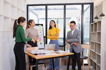 Group of Asian businesspeople talking together and brainstorm standing in modern office, Business startup and company strategy planning concept.