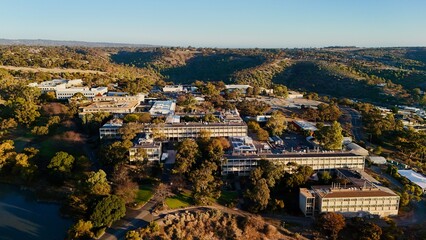 Obraz premium Flinders University, Central Park, Bedford Park, South Adelaide, South Australia - Aerial Image at Sunset Showing Academic Buildings, Carparks, Bushland, and Hilly Landscape in Golden Light