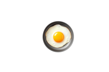A single fried egg with a runny yolk in a dark gray pan, isolated on green. background removed