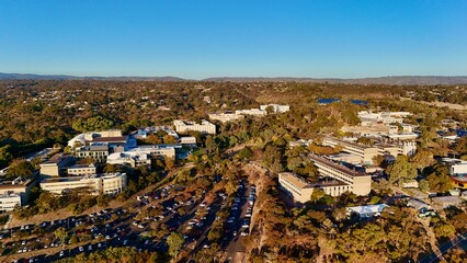 Obraz premium Flinders University, Central Park, Bedford Park, South Adelaide, South Australia - Aerial Image at Sunset Showing Academic Buildings, Carparks, Bushland, and Hilly Landscape in Golden Light