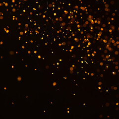 Golden confetti falling on black background