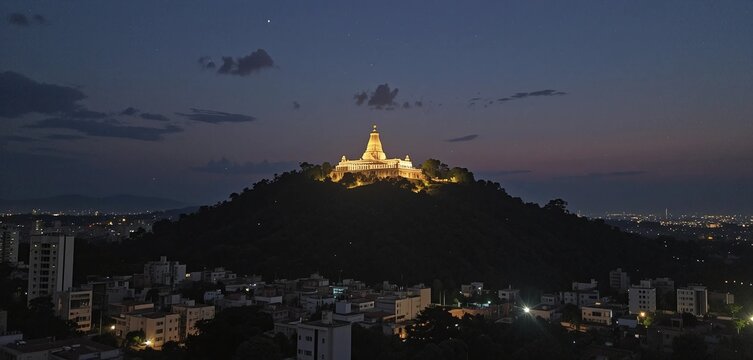 Coimbatore at nightfall, where the illuminated Marudhamalai Temple sits serenely on its hill, the city beneath shimmering like stardust scattered across the land.


