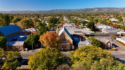 Unley Uniting Church, Unley, South Australia: Aerial Image in Autumn Featuring Historic Stone Church, Colourful Trees, Heritage Architecture, and Adelaide Hills in the Background