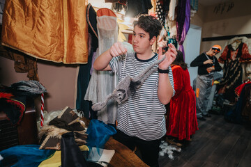 Young actors organize and adjust costumes backstage in a lively theater setting, preparing...