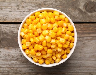 Close-up of fresh yellow corn kernels in white bowl on rustic wooden table