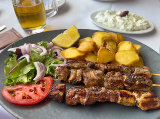 souvlaki skewers with tzatziki and garlic potatoes and tomato