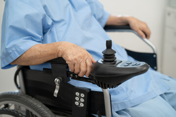 Asian senior woman patient on electric wheelchair with remote control at hospital, healthy strong medical.
